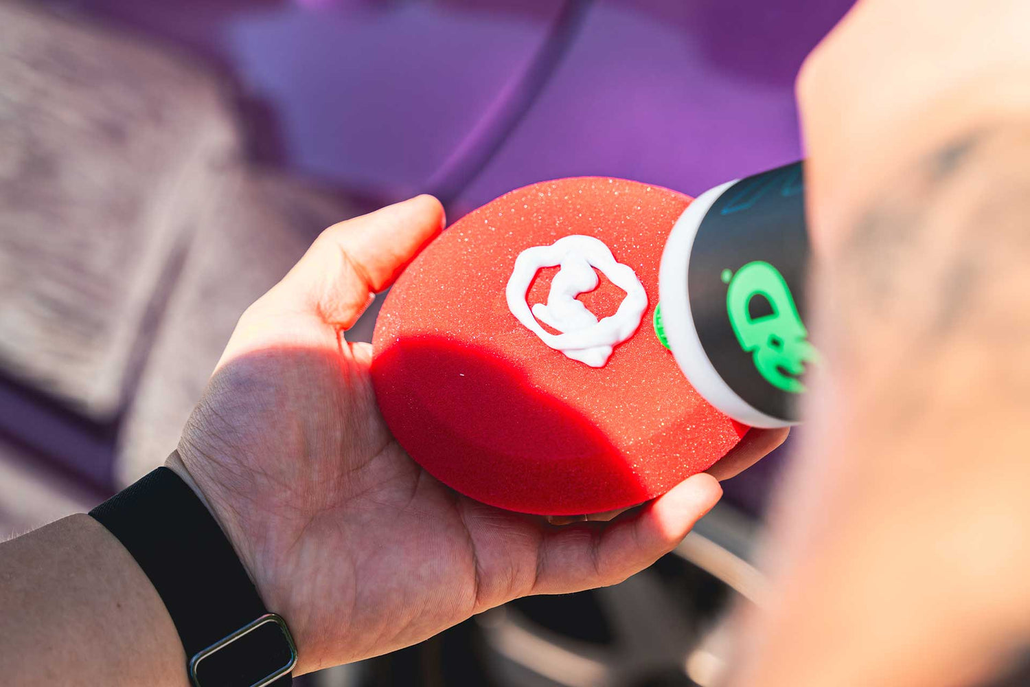 detailer applying ceramic wax to red applicator pad