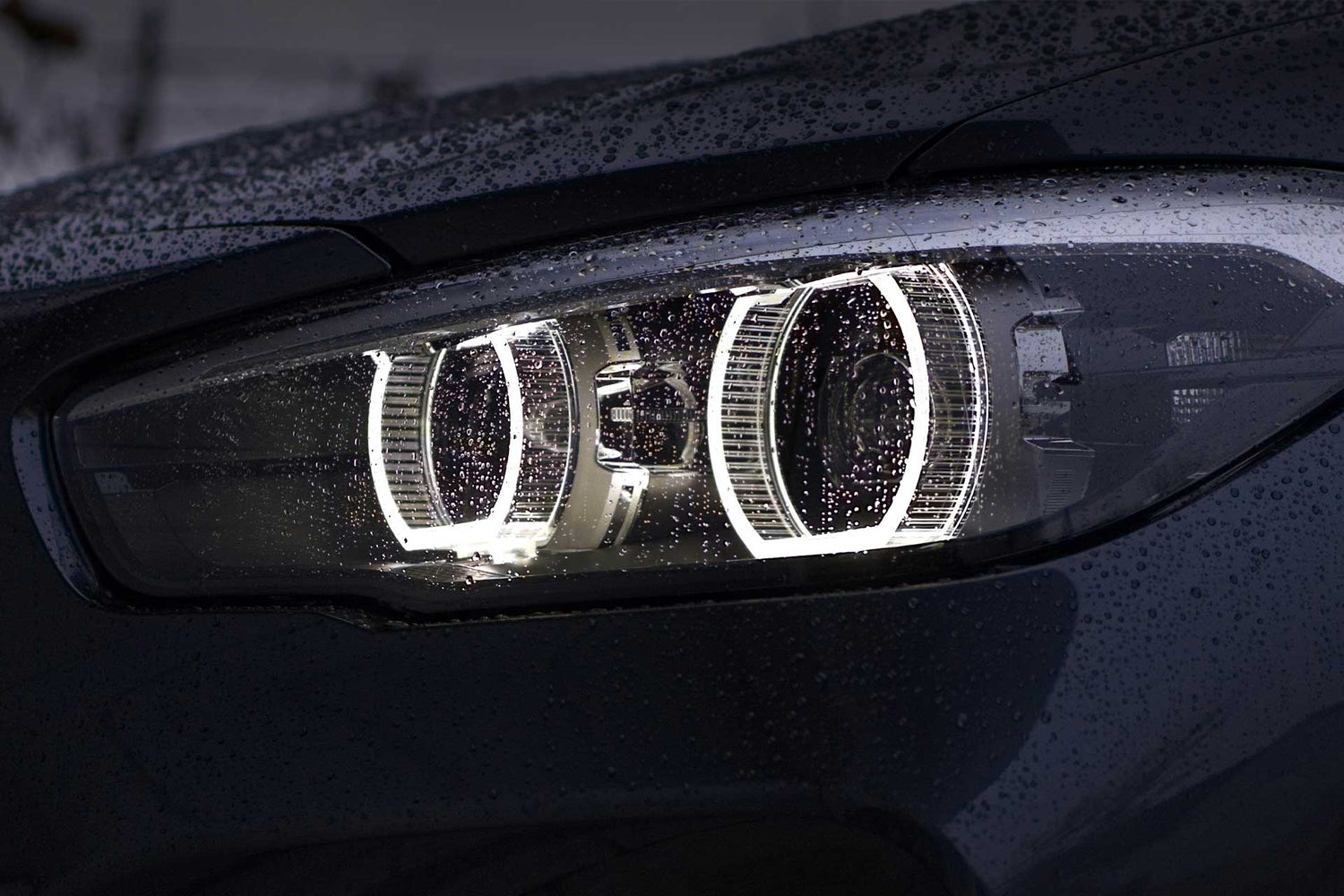 bmw headlights with rain droplets on lens