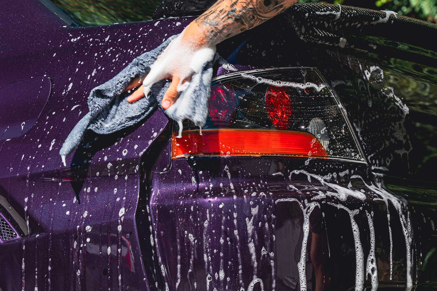 detailer washing purple car with car shampoo
