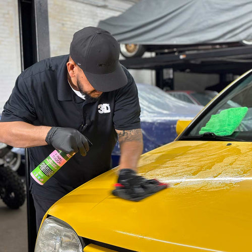 wiping hood of yellow volkswagen gti with clay towel
